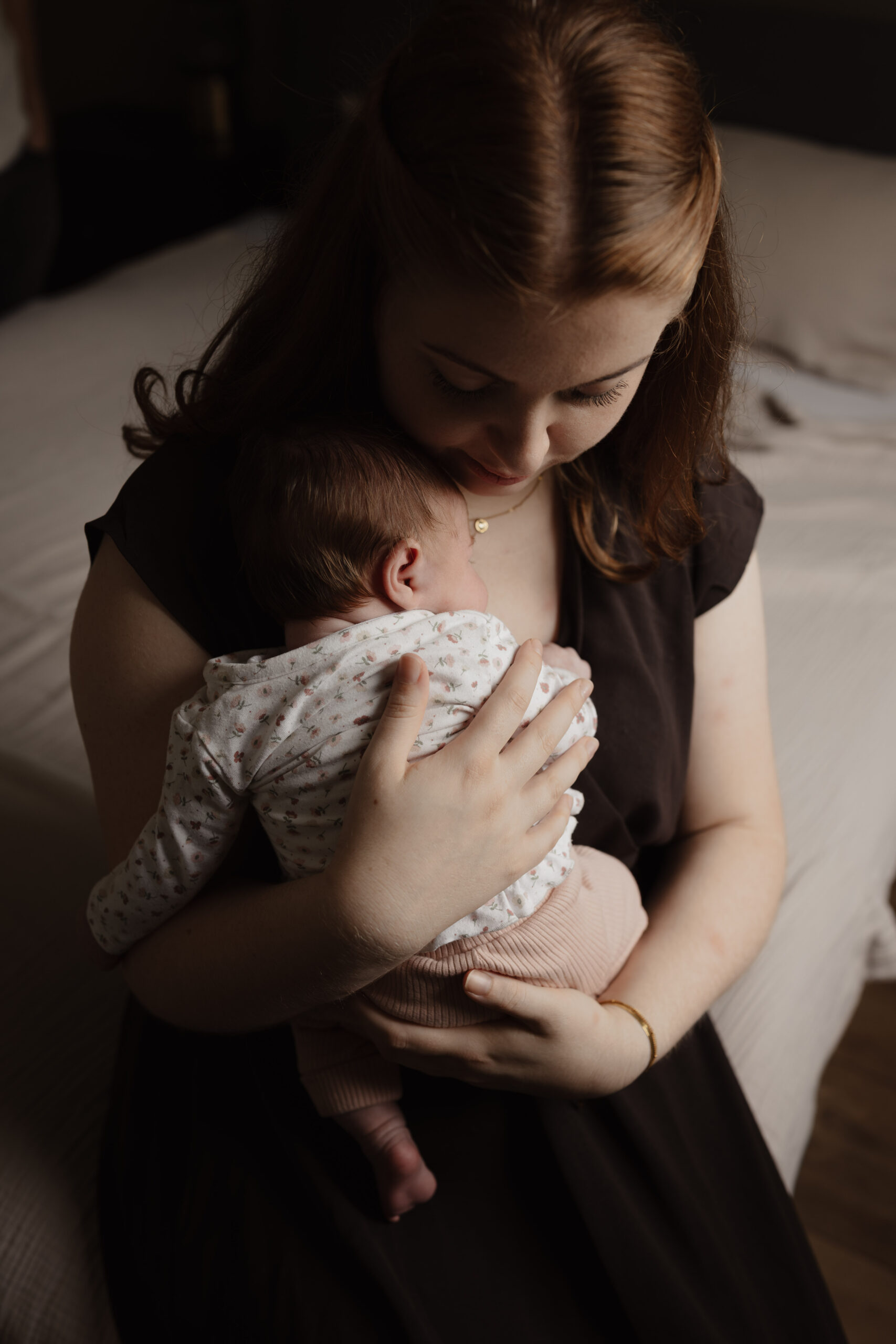 Pasgeboren baby in een zachte wikkeldoek tijdens een newbornshoot